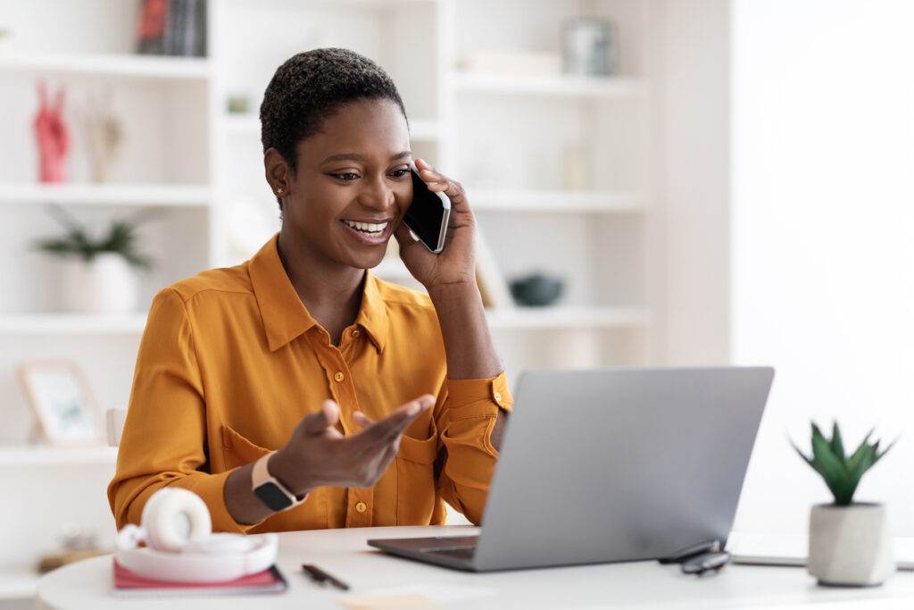 A woman utilizing Virtual IT Services while sitting at a desk with a laptop.