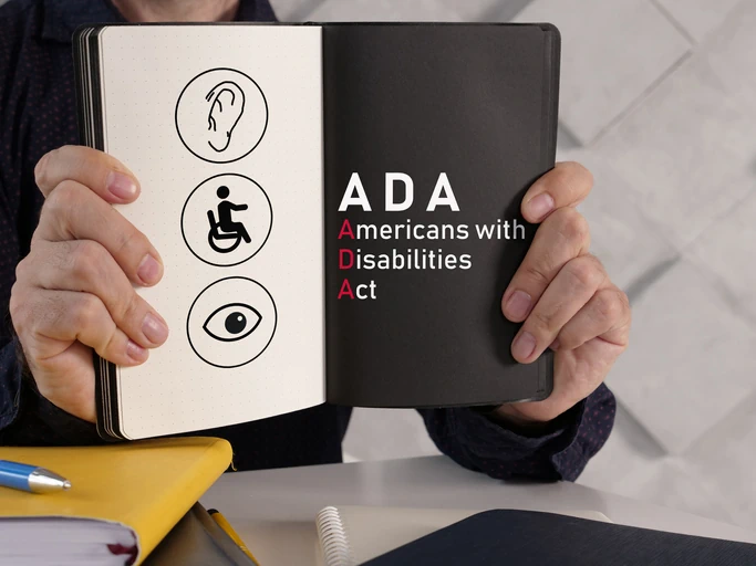 Man holding journal with the text ADA, Americans with Disabilities Act.