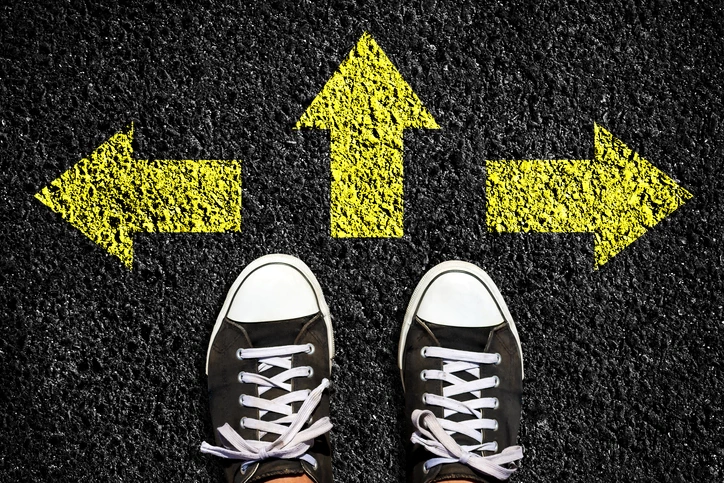 A pair of sneakers on a black road showing WCAG & ADA compliance with arrows pointing in different directions.