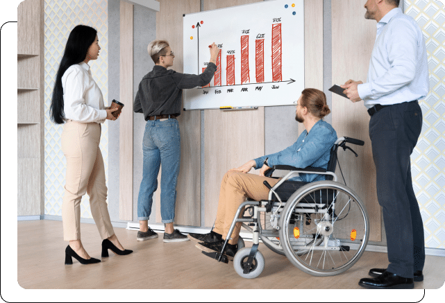 Four professionals analyzing a bar chart during a meeting, with one individual using a wheelchair.