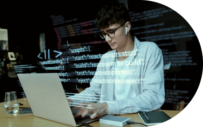 A focused individual programming on a laptop with code projected in the background.